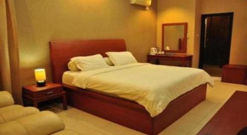 a bedroom with a large bed and a mirror at Hotel Minahasa in Manado