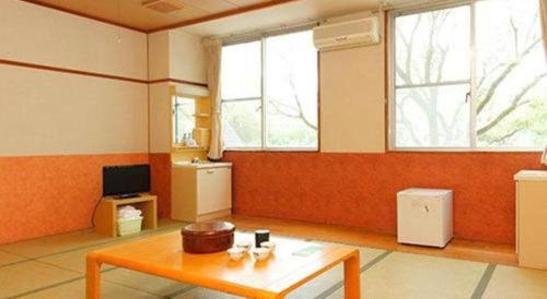 a living room with a table and two windows at Hotel SP Haruno in Kochi