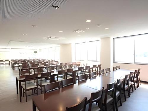 a large room with tables and chairs and large windows at Hotel SP Haruno in Kochi