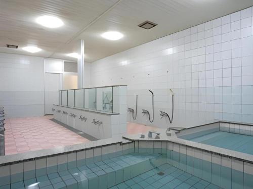 a bathroom with a swimming pool and a tub at Hotel SP Haruno in Kochi