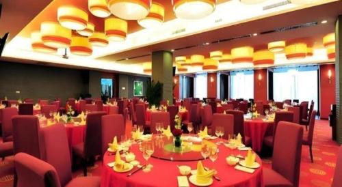 a dining room with red tables and red chairs at Xiangsheng Century Hotel Zhuji in Shaoxing