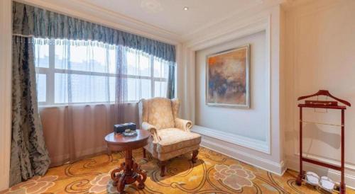 a living room with a chair and a window at Zhengzhou Yiquan International Hotel in Zhengzhou