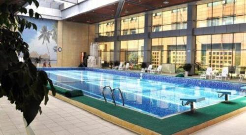 a large swimming pool in a building with swans on it at Zhengzhou Yiquan International Hotel in Zhengzhou