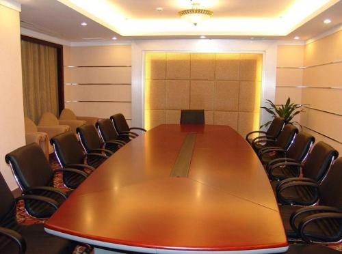 a conference room with a large wooden table and chairs at Quanzhou Royal Prince Hotel in Quanzhou