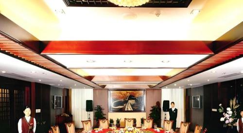 a dining room with tables and chairs and a chandelier at Quanzhou Royal Prince Hotel in Quanzhou
