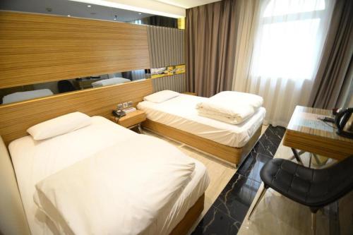 a hotel room with two beds and a desk at Hong Thai Hotel in Macau