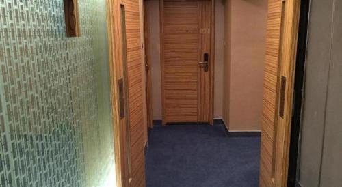 a hallway with wooden doors and a glass wall at Hong Thai Hotel in Macau