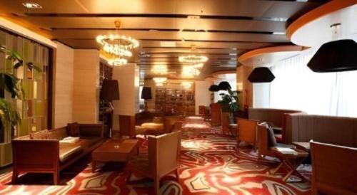 a restaurant with chairs and tables in a lobby at The Prosperous City Hotel Weifang in Weifang
