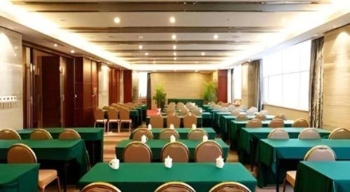 a conference room with green tables and chairs at The Prosperous City Hotel Weifang in Weifang