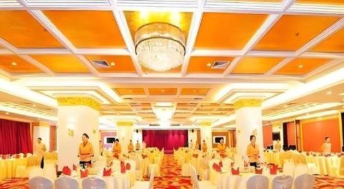 a banquet hall with white tables and white chairs at Jinjiang Grandlink Hotel in Quanzhou