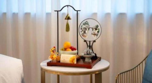 a small table with a mirror and fruit on it at Jiaxing Sunshine Hotel in Jiaxing