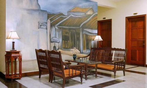 a living room with a table and chairs and a painting at Gia Bao Hotel Bac Ninh in Hanoi