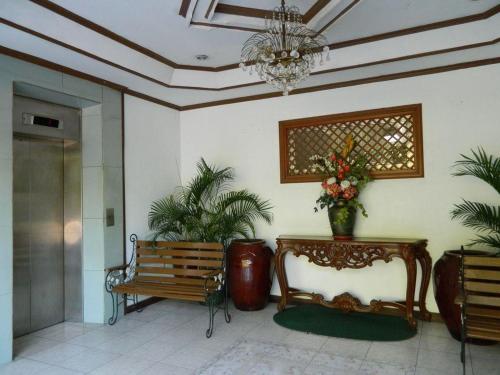 a lobby with a bench and a chandelier and plants at DJ Paradise Hotel in Malolos