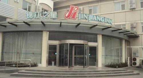 an entrance to a building with a sign on it at Magnotel Business Jining Huancheng North Road in Jining