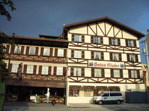 a building with a white van parked in front of it at Swiss Chalet in Angeles