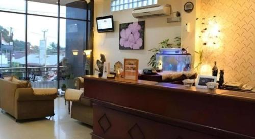 a lobby with a bar with a fish tank at Hotel Dynasty in Tarakan