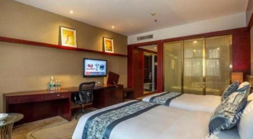 a hotel room with two beds and a desk and a computer at Quanzhou Jinjiang Hollyston Hotel in Quanzhou