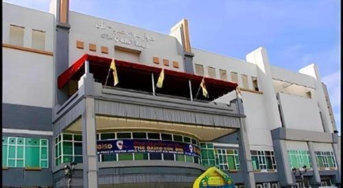 a large white building with flags hanging from it at Kiulap Plaza Hotel in Bandar Seri Begawan
