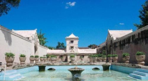 a large house with a swimming pool and a building at Griya Jogja Hotel in Yogyakarta