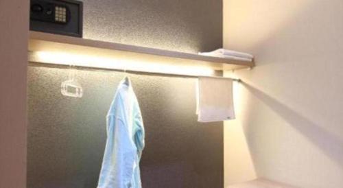 a refrigerator with a towel hanging on a wall at Griya Jogja Hotel in Yogyakarta