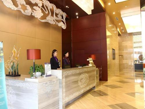 two women standing at a counter in a lobby at Chengdu Antai Century Hotel in Chengdu