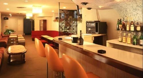 a bar in a restaurant with orange chairs and a counter at Yugawara Onsen Hotel Akane in Yugawara