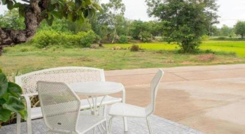two chairs and a table and a white table and chairs at Baan Kula Mahasarakam in Maha Sarakham