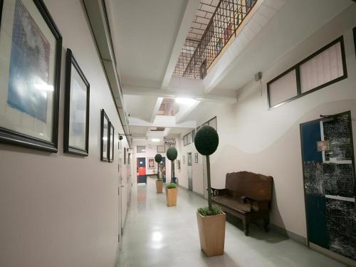 a hallway of a hospital with a piano and plants at Numsin Hotel in Ratchaburi