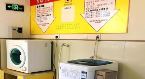a washing machine sitting on top of a microwave at 7 Days Inn Nanjing Gaochun Metro Station in Gaochun