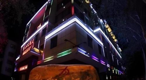 a building with neon lights on the side of it at Dunhuang Dunhe Hotel in Dunhuang