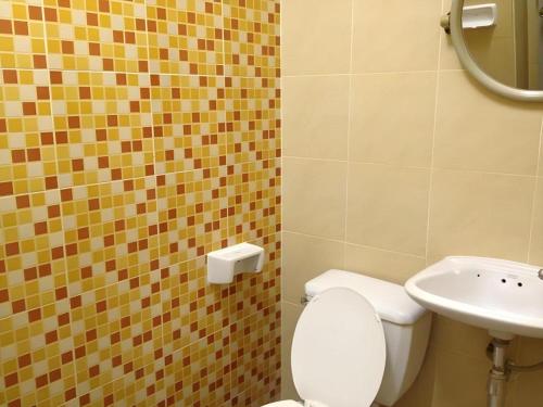 a bathroom with a toilet and a sink at Numsin Hotel in Ratchaburi