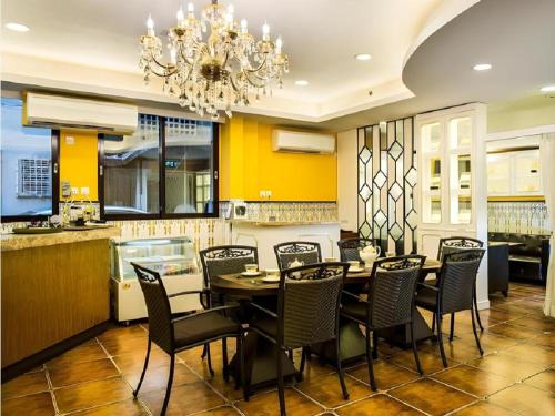 a dining room with a table and chairs and a chandelier at Happy Family Hotel in Macau