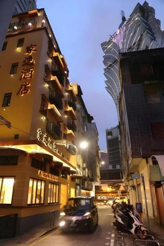a building on a city street at night with cars at Happy Family Hotel in Macau