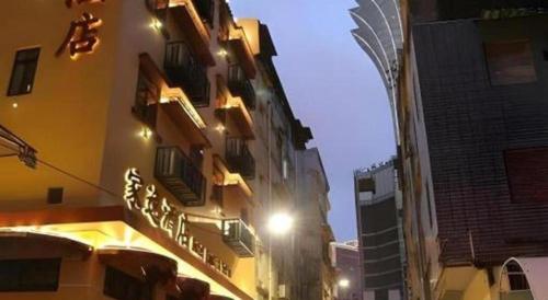 a building with a sign on the side of it at Happy Family Hotel in Macau