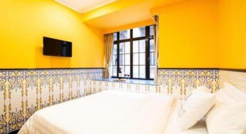 a bedroom with a white bed with a window at Happy Family Hotel in Macau
