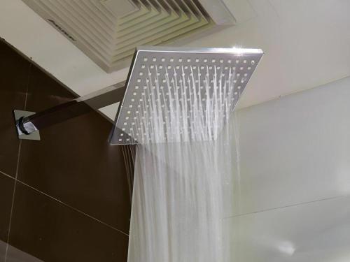 a shower with a shower curtain in a bathroom at 7 Days Premium Tongliao Train Station Branch in Tongliao