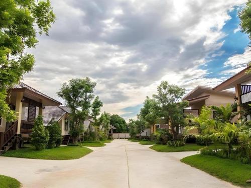 a driveway in a residential neighborhood with houses at Tong Hotel in Maha Sarakham