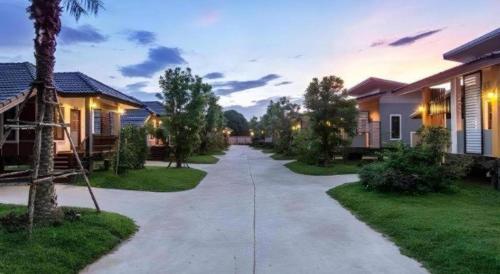 a walkway through a residential neighborhood with houses at Tong Hotel in Maha Sarakham
