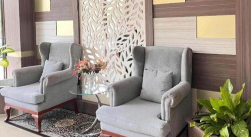 two chairs and a table in a room at Hotel Mekkah Banda Aceh in Banda Aceh