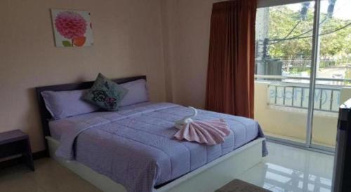 a bedroom with a bed and a large window at V-House Hotel in Trang