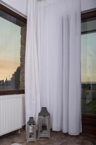 a room with white curtains and two tables at S4Sani in Sani Beach