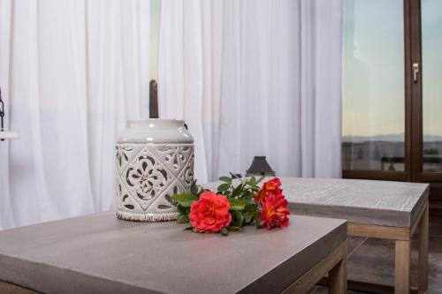 a table with a vase and flowers on it at S4Sani in Sani Beach
