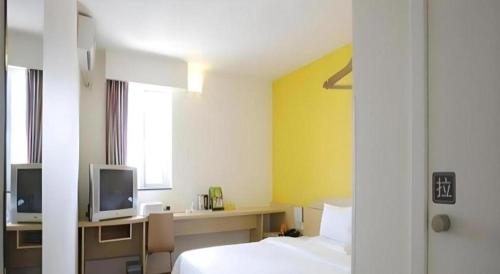 a hotel room with a bed and a tv at 7 Days Inn Luoyang Wangcheng Park Metro Station in Luoyang