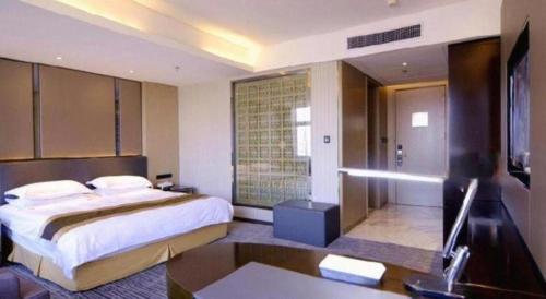 a bedroom with a large bed and a bathroom at Harbin Splendent Hotel in Harbin