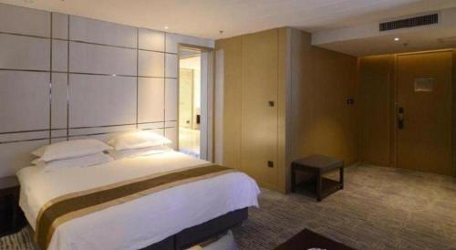 a bedroom with a large bed in a hotel room at Harbin Splendent Hotel in Harbin