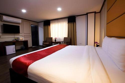 a bedroom with a large white bed with a red blanket at Horizon Hotel in Olongapo