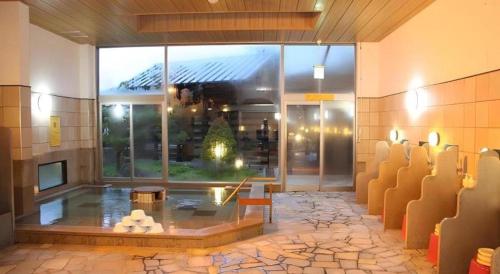 a lobby with a room with a fireplace and chairs at Hotel Royal Hill Fukuchiyama and Spa in Fukuchiyama