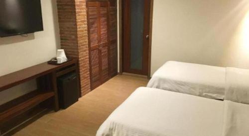 a hotel room with two beds and a television at Mango Valley Hotel in Olongapo