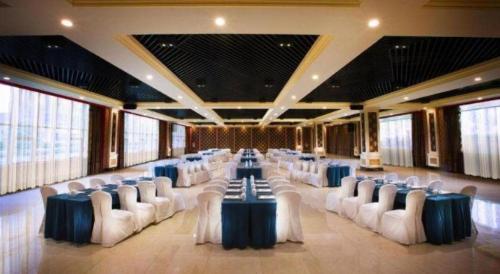a large banquet hall with white chairs and tables at Tongxiang Inspirock Hotel in Jiaxing