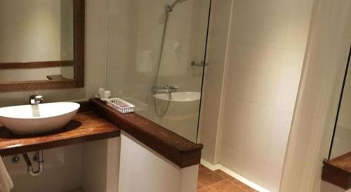 a bathroom with a sink and a glass shower at Mango Valley Hotel in Olongapo